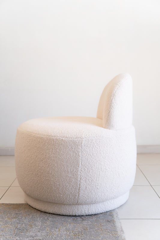 מבט אחורי של כורסה עגולה מבד בוקלה שמנת