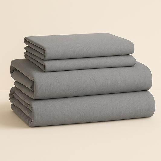 סט מצעים אפור מקופל בצורה מסודרת, כולל סדין, ציפית וציפת שמיכה עשויים כותנה טבעית – דגם Dream Basic מבית DreamIt.