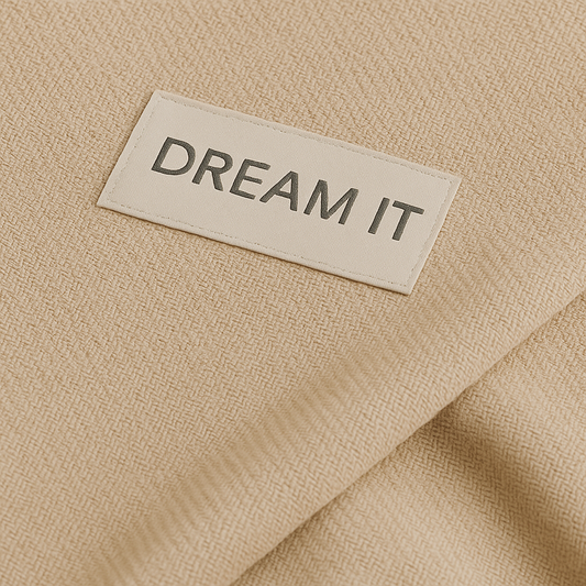 שקית אחסון שמיכת חורף עם לוגו DREAM IT בצבע אפור על רקע שמנת – אריזת בד רחבה עם שרוך, בעיצוב מינימליסטי איכותי