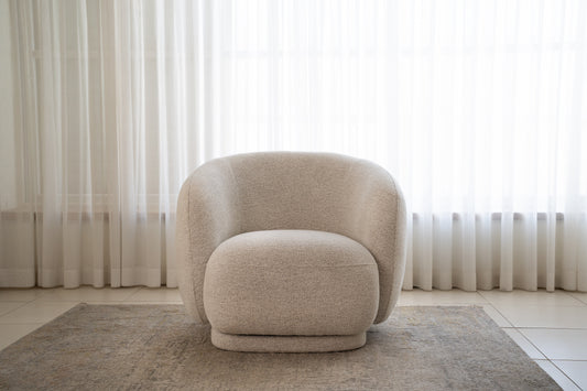 כורסה מבד בוקלה בצבע שמנת בחלל סלון מודרני