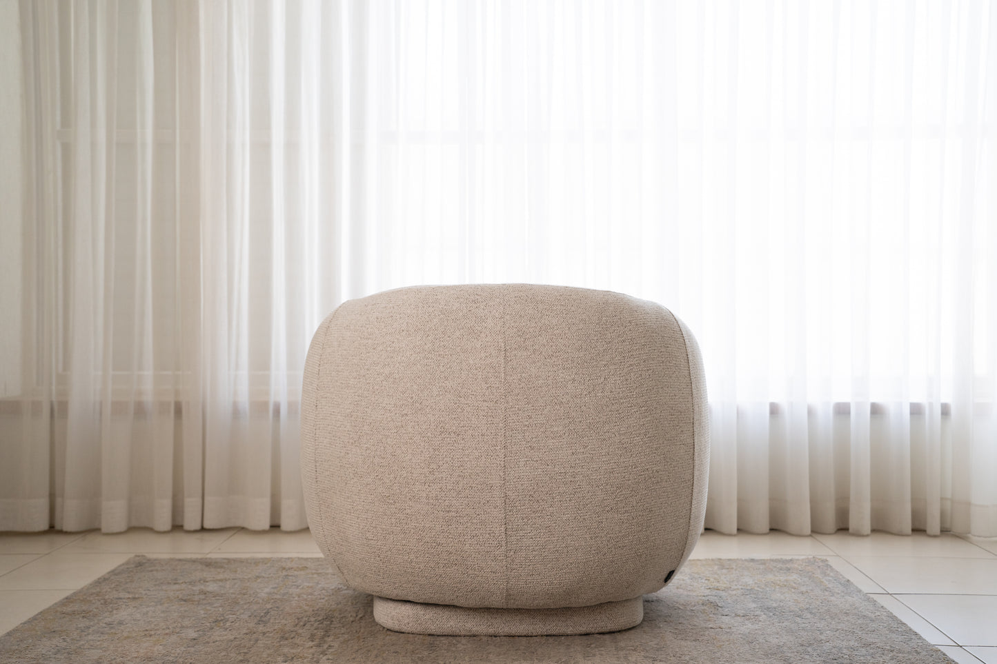 מבט אחורי של כורסה עגולה מבד בוקלה בצבע שמנת