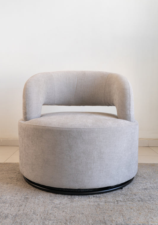 כורסה אפורה בעיצוב מודרני בפינת סלון מוארת.