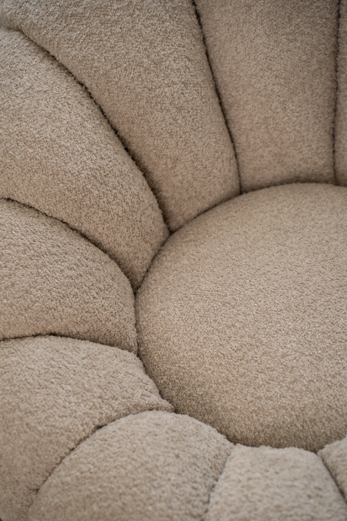 תקריב בד בוקלה איכותי של כורסה בצבע שמנת.