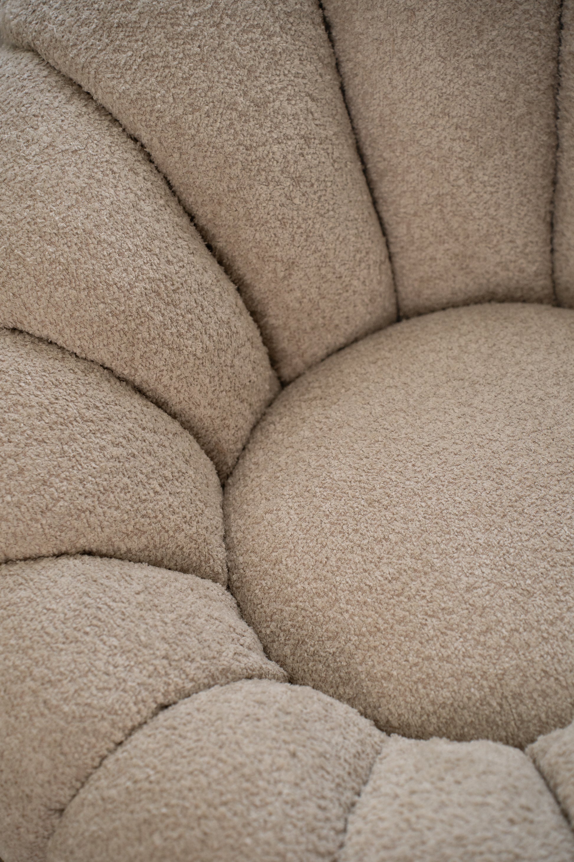 תקריב בד בוקלה איכותי של כורסה בצבע שמנת.