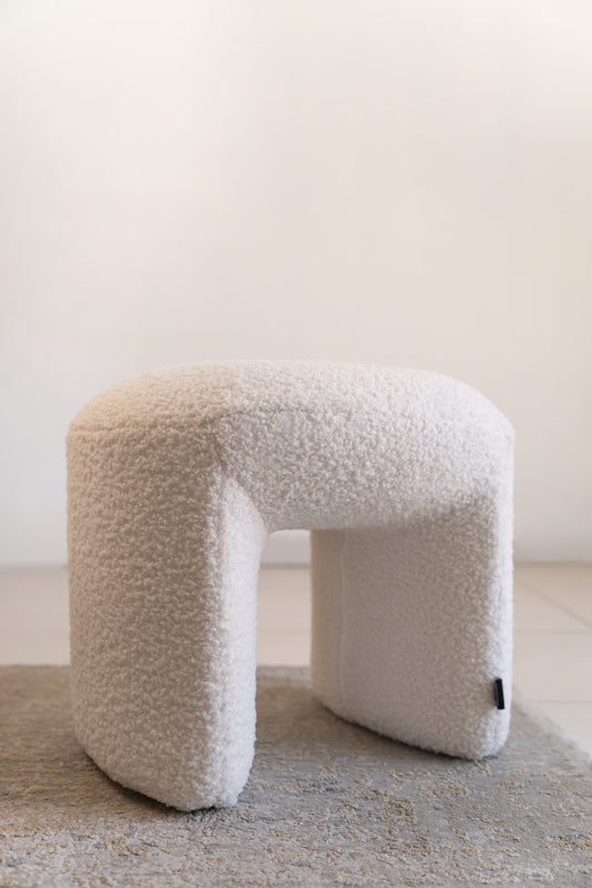 הדום מעוצב מבד בוקלה בצבע שמנת בזווית צד.