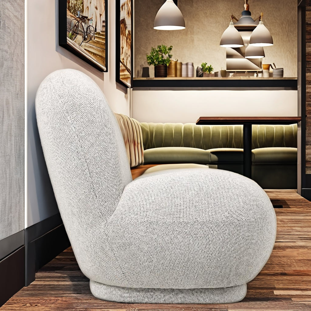 כורסא בוקלה Milano בחלל סלון מעוצב, על שטיח בהיר לצד שולחן צד מוזהב – השראה לעיצוב בית יוקרתי.