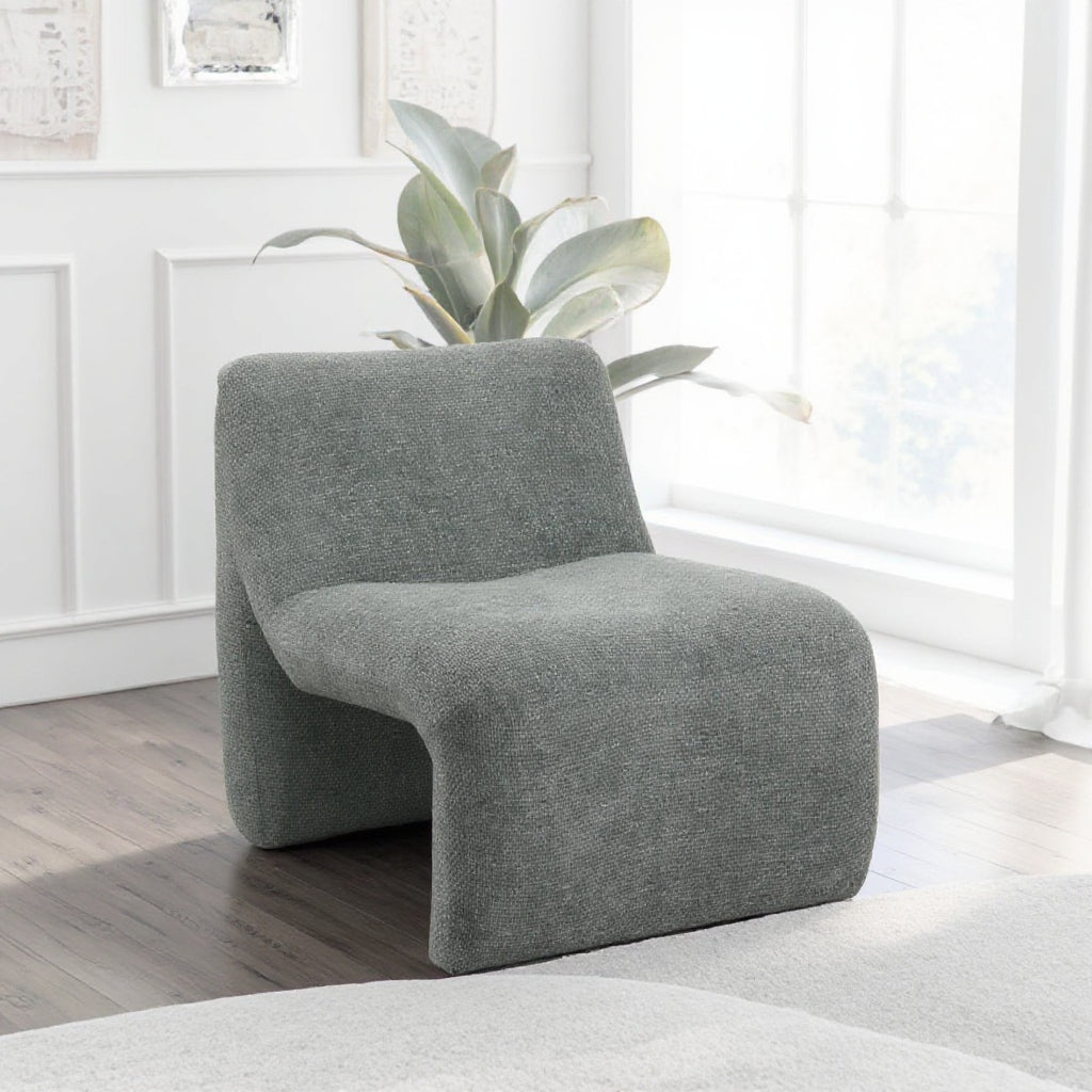 כורסה מודרנית “Kano” בגוון ירוק־אפור – מבט בזווית אלכסונית בחלל מואר.