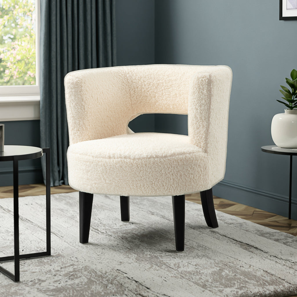 כורסה Taria מעוצבת עם רגליים שחורות ובד בוקלה רך